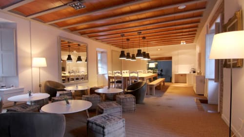 Moderna zona de descanso del Hotel Restaurante Can Carol en Capellades con techo de madera, lámparas colgantes y cómodos asientos.