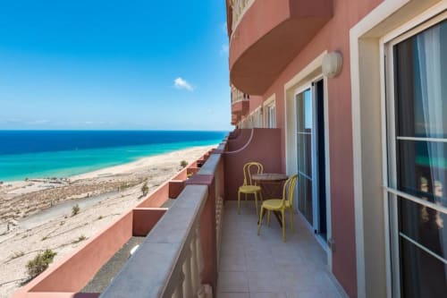 Terraza frente al mar en Smart Rent Fuerteventura con vistas al océano, playa de arena y aguas turquesas desde balcón privado