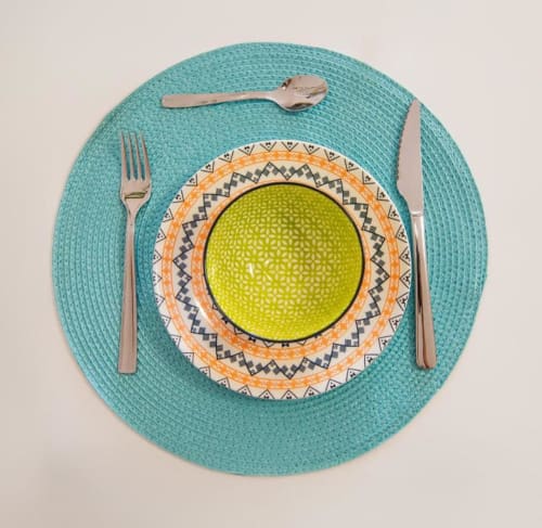 Elegante mesa decorada con mantel turquesa, plato decorativo y cubiertos en apartamento de Smart Rent Fuerteventura