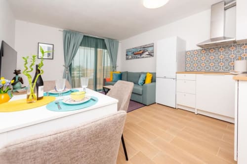 Apartamento de planta abierta en Smart Rent Fuerteventura con comedor, cocina y sala de estar con vistas al balcón