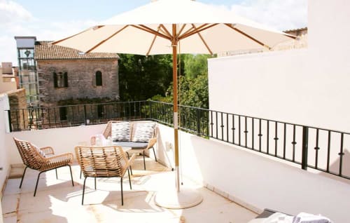 Amplia terraza de la casa NA BATLESSA en Artà con zona de descanso, sombrilla y vistas a la ciudad