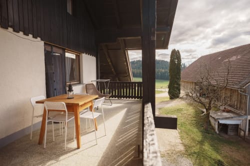 Covered terrace with wooden dining table at Kmetija Pečnik farm stay in Prevalje, mountain views