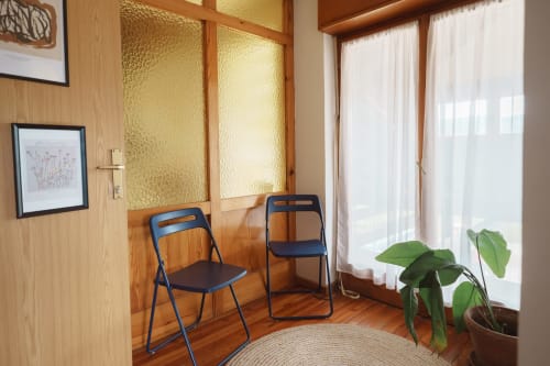 Bright seating area in Gank Apartment at Kmetija Pečnik with blue chairs, wooden furnishings, and mountain views through