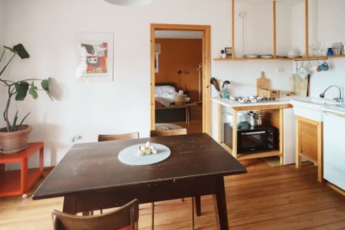 Modern kitchen and dining area in Gank Apartment at Kmetija Pečnik, Prevalje, with wooden table, stove, and hardwood floors