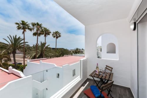 Balcón con tumbonas con vistas a palmeras y jardín en apartamento Smart Rent Fuerteventura, Tarajalejo
