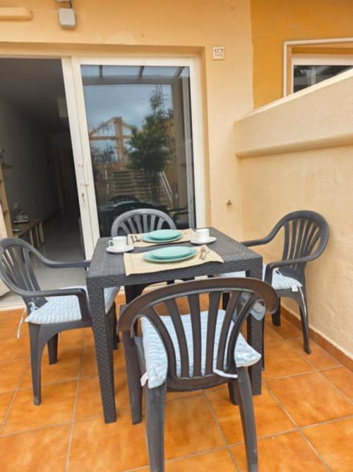 Terraza de comedor al aire libre en Smart Rent Fuerteventura con mesa preparada y vistas al jardín