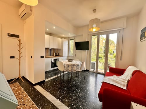 Appartamento moderno a Welcome Varigotti con vista mare, cucina aperta, zona pranzo, divano rosso e vetrate