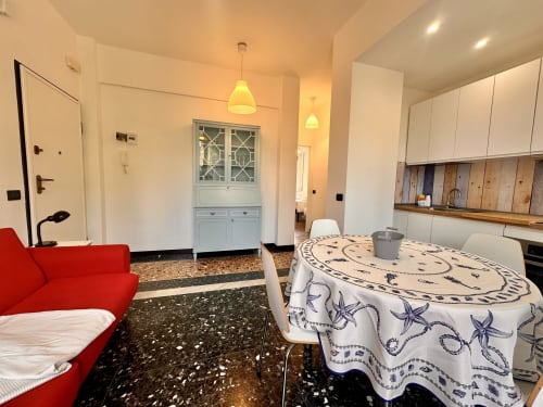 Moderno appartamento a Varigotti con open space, divano rosso, tavolo da pranzo, cucina attrezzata e accesso alla vista mare