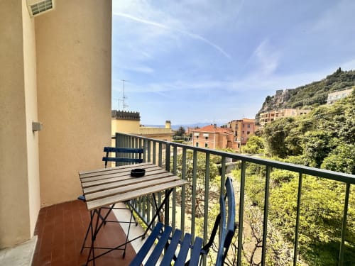 Balcone con tavolo dell'appartamento Antico Mulino a Varigotti, Italia, con vista su edifici colorati e la costa mediterranea