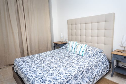 Dormitorio moderno del apartamento Bernardo en Smart Rent Fuerteventura con cabecero acolchado, ropa de cama azul estampada y beige