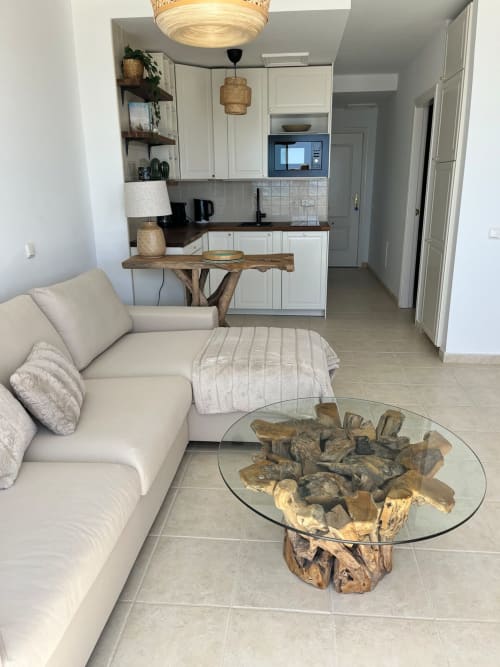 Sala de estar moderna con sofá crema, mesa de café de madera flotante y cocina abierta en Smart Rent Fuerteventura