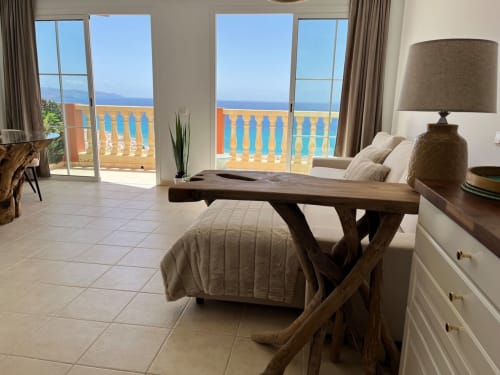 Luminoso salón con vistas al mar, mesa de comedor y balcón costero en Smart Rent Fuerteventura