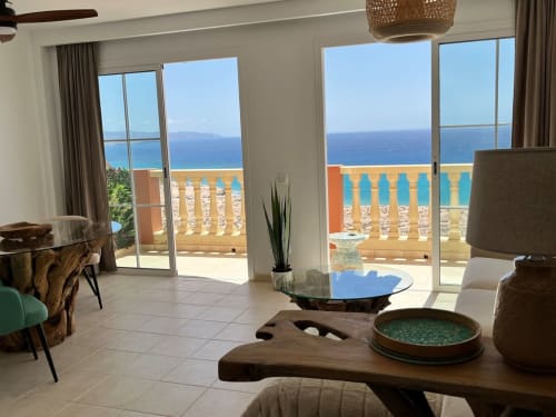 Luminoso salón frente al mar con vistas al océano, mobiliario moderno y acceso a balcón privado en Smart Rent