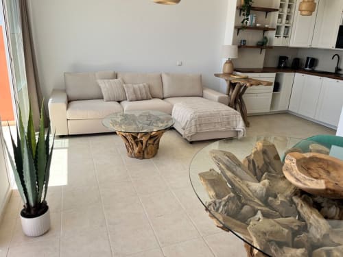 Moderna sala de estar en Smart Rent Fuerteventura con sofá beige, mesas de madera natural y cocina abierta