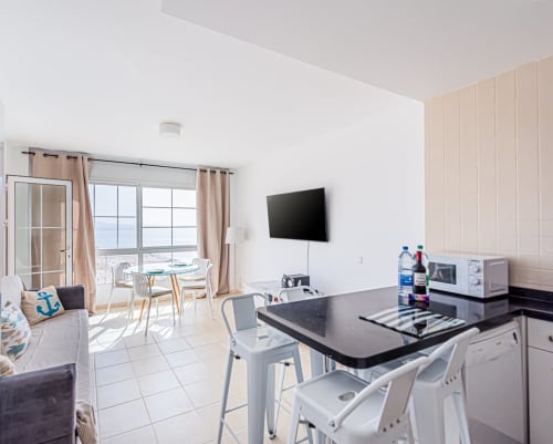 Cocina moderna y sala de estar con vistas al océano desde el balcón en Smart Rent Fuerteventura