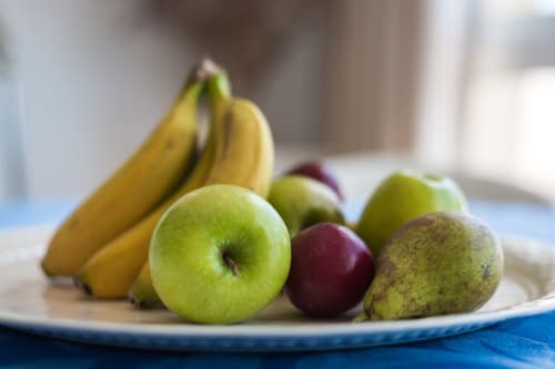 Frutero con plátanos, manzanas verdes, pera y ciruela en el apartamento Smart Rent Fuerteventura