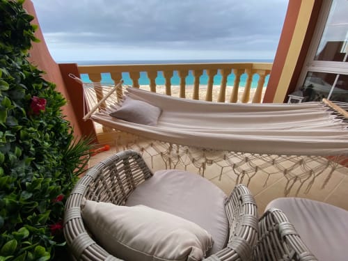 Balcón frente al mar con hamaca, sillas de mimbre y vista al océano en Casa Kiteloop, Fuerteventura