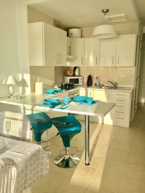 Cocina y comedor modernos en apartamento Dolce Vita de Smart Rent Fuerteventura con taburetes turquesas y blanco