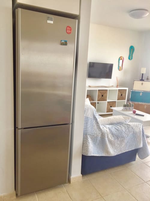 Apartamento Dolce Vita en Smart Rent Fuerteventura con refrigerador de acero inoxidable, cama, TV, estanterías y diseño moderno