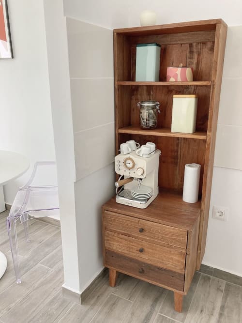 Estantería de madera en apartamento Fuerte Hygge con cafetera espresso, suministros de café y artículos de baño