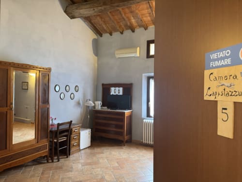 Camera Lapislazzuli presso l'Agriturismo Aggazzotti a Colombaro, Italia, con travi in legno, arredamento rustico e