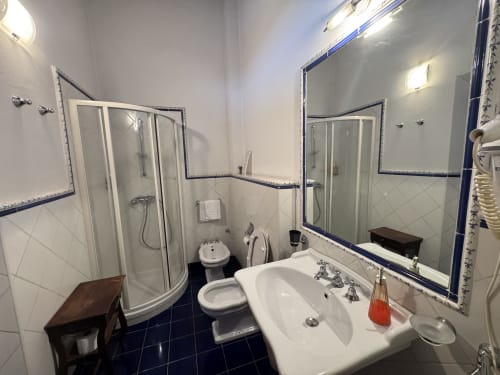 Bagno dell'Agriturismo Aggazzotti a Colombaro con doccia, lavandino, WC e specchi con bordi blu