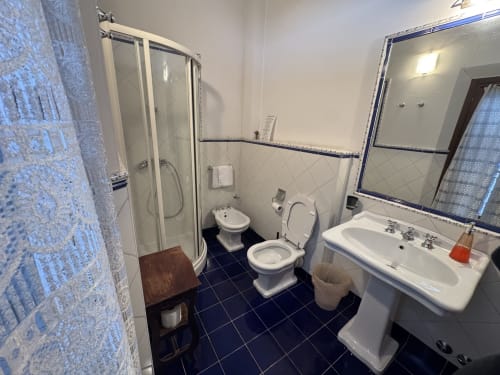 Bagno della Camera 5 presso Agriturismo Aggazzotti con doccia, doppio lavabo, bidet e pavimentazione in piastrelle blu
