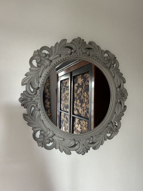 Ornate gray circular mirror reflecting window at Le Clos d'Azel boutique hotel in Alsace