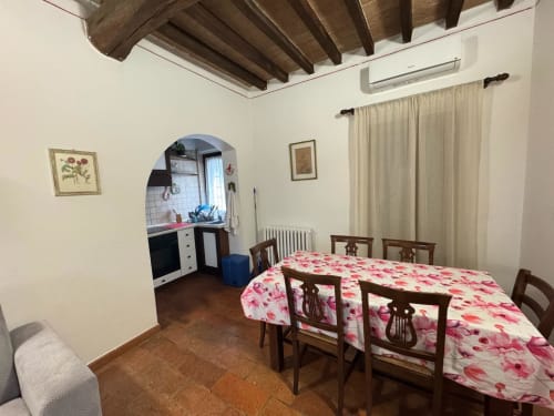 Rustic dining room with floral tablecloth and wooden chairs at Agriturismo Aggazzotti in Colombaro, Italy