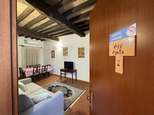 Appartamento Agata presso l'Agriturismo Aggazzotti con divano, zona pranzo, travi a vista e cartello vietato fumare
