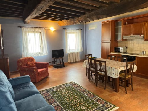 Spacious Zaffiro apartment at Agriturismo Aggazzotti with living area, dining table, kitchen, and terracotta floors