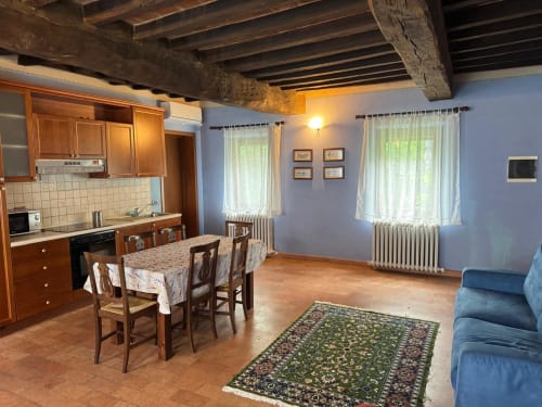 Agriturismo Aggazzotti Zaffiro apartment in Colombaro: rustic beamed ceiling, wooden kitchen, dining area, blue walls,