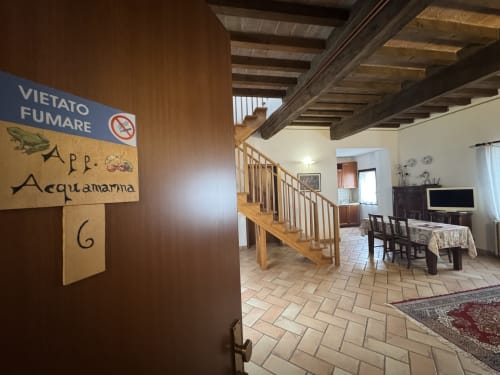 Acquamarina apartment entrance at Agriturismo Aggazzotti in Colombaro with wooden stairs and rustic Italian interior