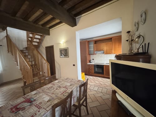 Acquamarina apartment at Agriturismo Aggazzotti with wooden stairs, kitchen, dining area and terracotta floors in Colombaro,
