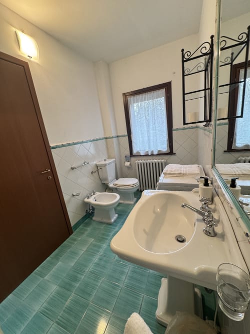 Spacious bathroom at Agriturismo Aggazzotti with sink, bidet, toilet, and mirror with ornate frame
