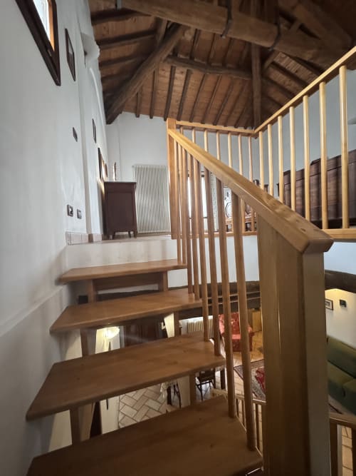 Wooden spiral staircase in Acquamarina room at Agriturismo Aggazzotti, Colombaro, Italy