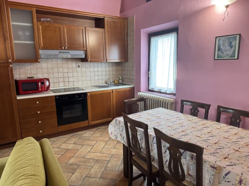 Kitchen and dining area of Appartamento 8 at Agriturismo Aggazzotti in Colombaro, Italy, featuring wooden cabinets and pink
