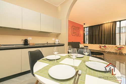 Zona pranzo dell'appartamento White House a Genova con cucina moderna, tavolo da pranzo e vista sulla città