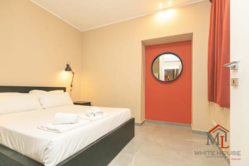 Appartamento ML White House a Genova con letto moderno, parete accent arancione e vista città