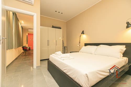 Camera da letto moderna nell'appartamento ML White House Genova Centro Storico con letto matrimoniale, armadio e vista sulla città