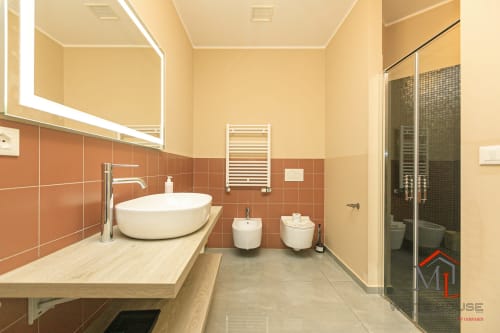 Bagno moderno presso ML White House Centro Storico Apartments, Genova con lavabo rotondo, piastrelle in terracotta, doccia e riscaldamento