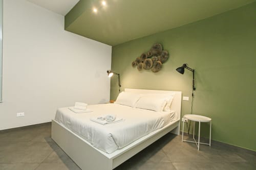 Camera moderna presso Centro Storico Apartments a Genova con letto bianco, pareti verde e illuminazione con vista città