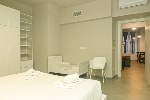 Moderna camera da letto a Genova con letto matrimoniale, letto per bambino, scrivania, armadio a muro e vista sulla città