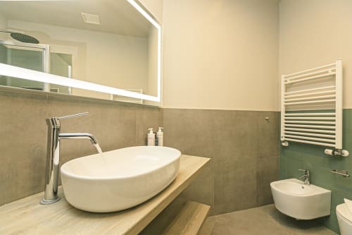 Bagno moderno con lavabo bianco a calice, rubinetto cromato, bidet e scaldasalviette riscaldato presso ML White House Centro Storico