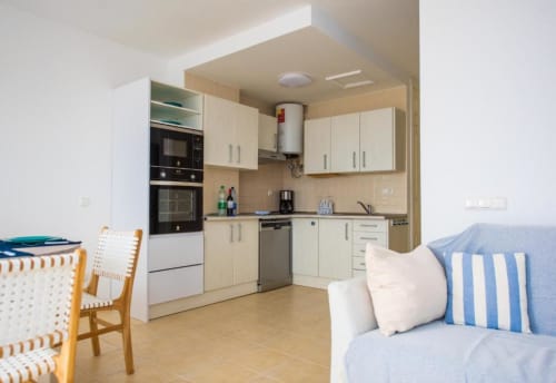 Cocina y sala de estar modernas en el apartamento Casa Laguna de Smart Rent Fuerteventura con mobiliario blanco y cómodo