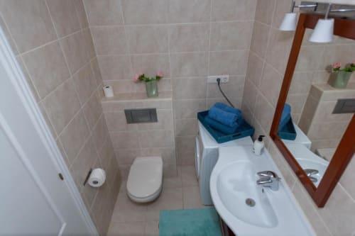 Baño limpio en apartamento Casa Laguna de Smart Rent Fuerteventura con inodoro, lavamanos, espejo y paredes alicatadas