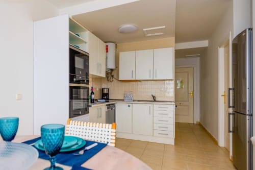 Cocina y comedor modernos en el apartamento Casa Laguna de Smart Rent Fuerteventura con muebles blancos y detalles turquesas