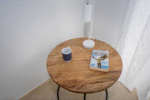 Mesa redonda de madera en apartamento Casa Laguna de Smart Rent Fuerteventura con taza decorativa, portarrollos de papel y