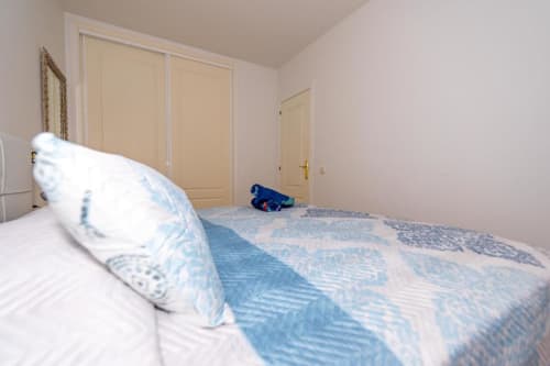Dormitorio luminoso con ropa de cama azul y blanca en el apartamento Casa Laguna de Smart Rent Fuerteventura