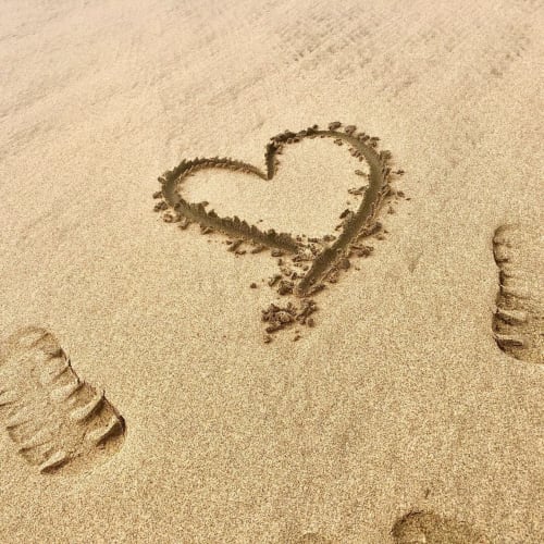 Corazón dibujado en la arena de la playa de Fuerteventura cerca del apartamento Smart Rent con acceso al océano